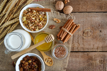 Fototapeta na wymiar Walnuts, granola, milk and honey on wooden background