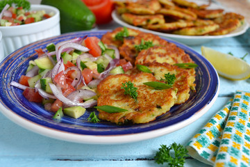 potato pancakes with green onions and sour cream on a wooden bac