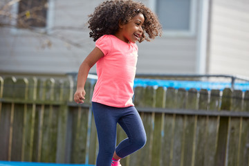 Fototapeta na wymiar Kid toddler girl jumping on a playground