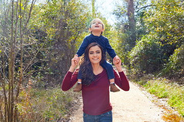 kid boy sit on mother shoulders walking park