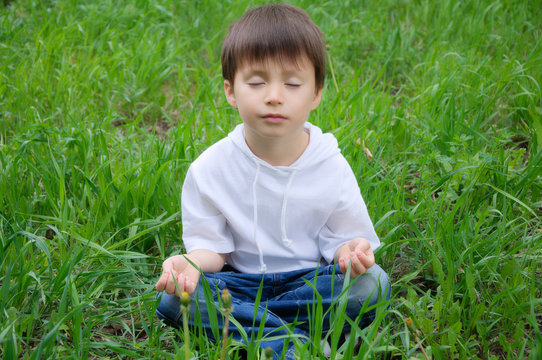 Boy sitting in meditation pose outdoor