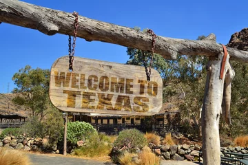Raamstickers old wood signboard with text " welcome to texas" hanging on a branch © luzitanija