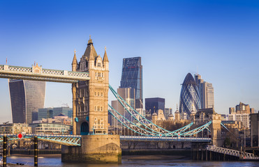 Fototapety  Londyn, Anglia – słynny most Tower Bridge w porannym słońcu z dzielnicą bankową w tle