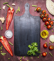 Healthy foods, cooking and vegetarian concept variety of vegetables and fruits are laid out around the cutting board, place for text, top view