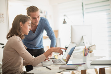 A young female architect and her colleague examining a project