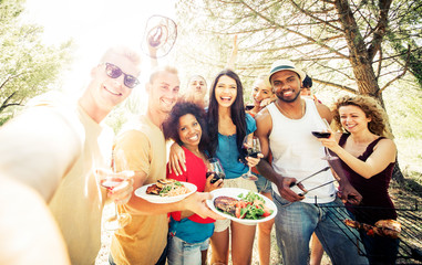 Group of friends making barbecue in the nature. Eating and sharing good mood