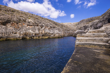 Malta - Blue Grotto with blue sky and clouds on a sunny day
