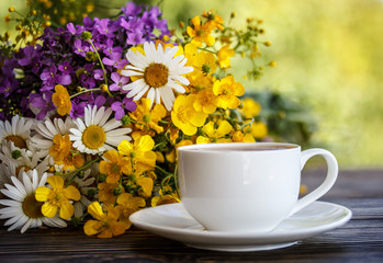 cup of coffee and flowers on the wooden table
