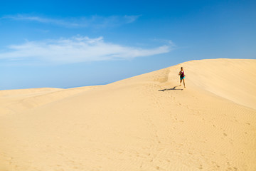 Woman running on desert dunes