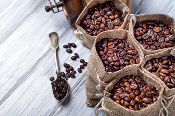 Jute bags filled with coffee and silver spoon