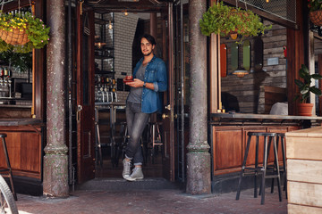 Obraz na płótnie Canvas Stylish young man at a cafe entrance