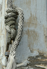 Fototapeta na wymiar Thin white rope against white chipping wood 