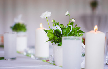 candles and daisies on table