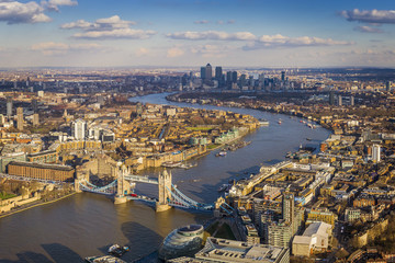 Obrazy na Plexi  Widok z lotu ptaka na panoramę Londynu, w tym Tower Bridge z czerwonym autobusem piętrowym, drapacze chmur Canary Wharf i Tamizy