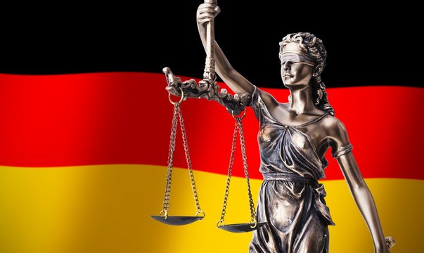 Themis with scale, symbol of justice on German flag background