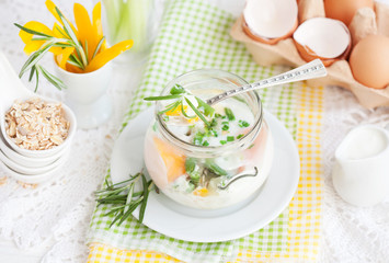 Breakfast: coddled eggs with green beans, yellow pepper, chives and rosemary in a glass jar. Selective focus.
