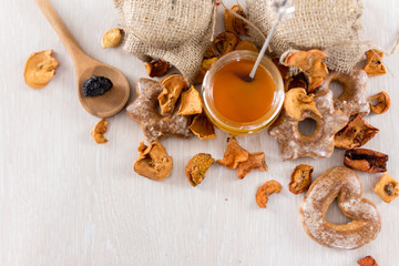 New trend honey, tea leaves, dried apples on a white wooden background
