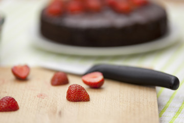 Close up of a halved strawberry on a chopping board