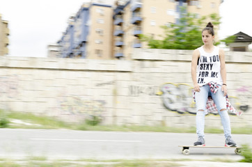 Beautiful young woman driving skateboard