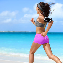 Obrazy na Plexi  Dopasuj kobieta działa ćwiczenia cardio na tropikalnej plaży latem. Nie do poznania sportowiec biegacz jogging intensywne noszenie uchwytu na opaskę na telefon do motywacji muzycznej do słuchania w aplikacji na smartfona.