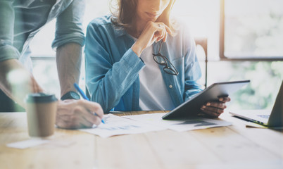 Brand Managers Working Modern Studio.Woman Showing Market Report Digital Tablet.Producer Department Work New Startup Project.Researching Process Wood Table.Horizontal.Burred Background.Film effect.