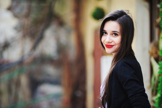 beautiful girl with long hair in a white shirt and a black cardigan looking with painted red lipstick lips