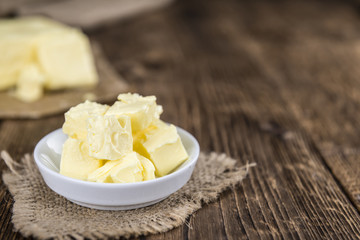 Piece of Butter on wooden background (selective focus)