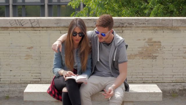Young couple reading a book and talking.