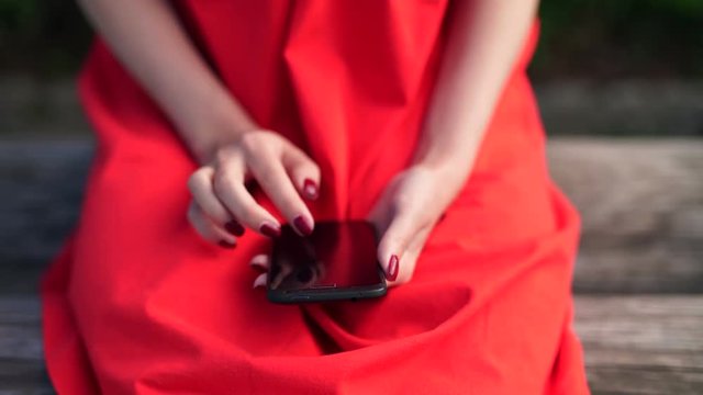 woman in red dress holding a phone with app mobile wallet