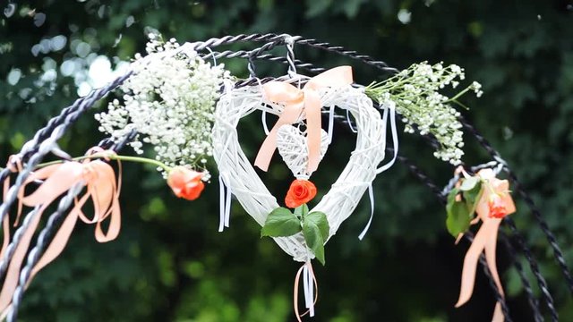 Wedding altar decorated with white,orange roses and heart made of cloth waving in the wind