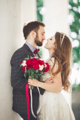 Beautiful couple, bride and groom posing near big white column