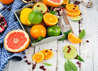 Fresh citrus fruits on a white wooden table.