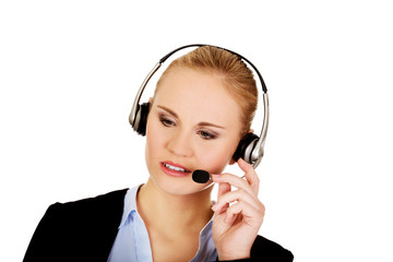 Young woman helpline operator is trying to hear something headphones