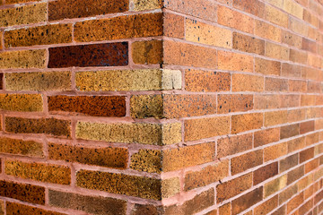 Corner and texture of vertical bright brown brick wall