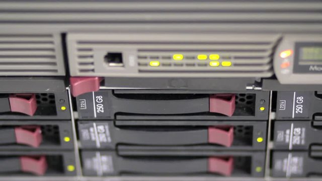 Blinking LEDs of server stack with hard drives in a datacenter, backup sewrvers in telehouse, datacentre
