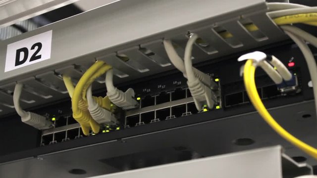 connected switches in technology telecomunication room with patch cables, internet service provider equipment in datacentre, telehouse