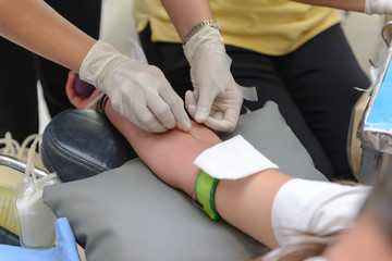 Fototapeta premium Nurse giving an intravenous injection to blood donor at blood donation