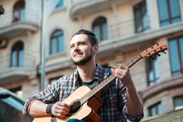 Man playing on guitar outdoors
