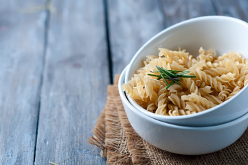 Raw pasta on wooden background