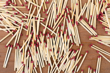 new matches scattered on a brown wooden background