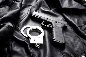 Rifle, gun, knife with sheath, compass and notebook with pen on on black cloth