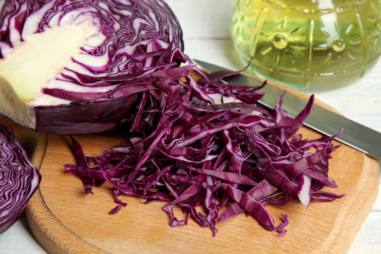 chopped cabbage on wooden chopping Board near the knife and sunflower oil
