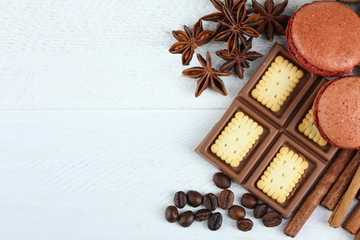 candies and chocolates with cinnamon and anise with coffee beans on wooden white background