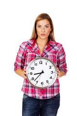 Young serious woman holding clock