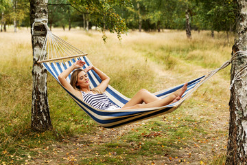 Obraz na płótnie Canvas Young blonde woman resting on hammock