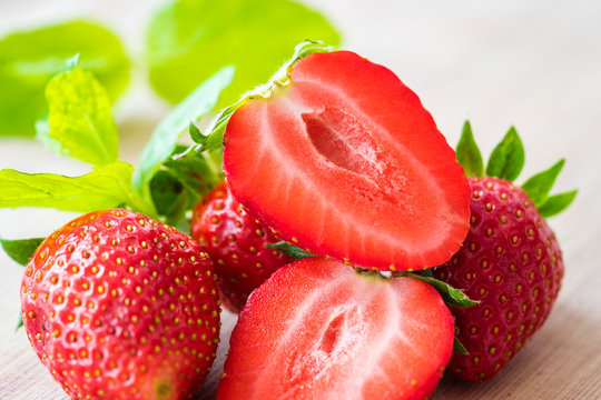 Pile of fresh strawberries on a wooden table. Detail view.