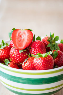 Detail view of fresh strawberries in a bowl. Selective focus. Vertical view.