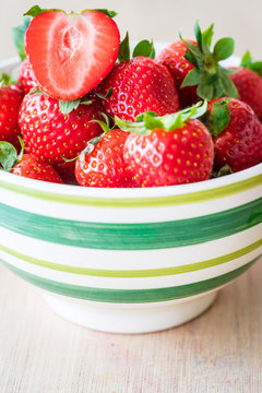 Close-up view of fresh strawberries in a bowl. Vertical shot. Selective focus.
