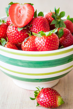 Detail view of fresh strawberries in a bowl. Selective focus. Vertical view.