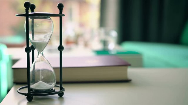 Sand falls quickly through an hourglass